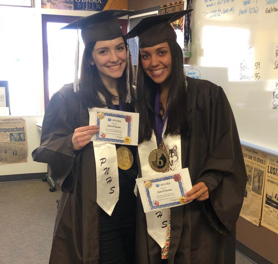 Isabel Reid (at left) and Hannah Thomas Perez (at right) pose with their mock-diplomas. Photo courtesy of Hannah Thomas Perez.