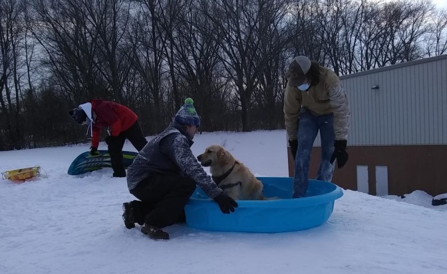 Senior Judson Fargo prepares to ride down Huskie Hill with Hobbs in a plastic kiddie pool. This was just one of many sledding feats attempted by the seniors at WinterFest.
