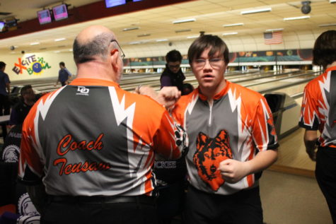 Junior Brady Louthan and coach Teusaw celebrate a good shot. Louthan contributed to the team winning the match against Battle Creek Lakeview which left the Northern mens team undefeated. 