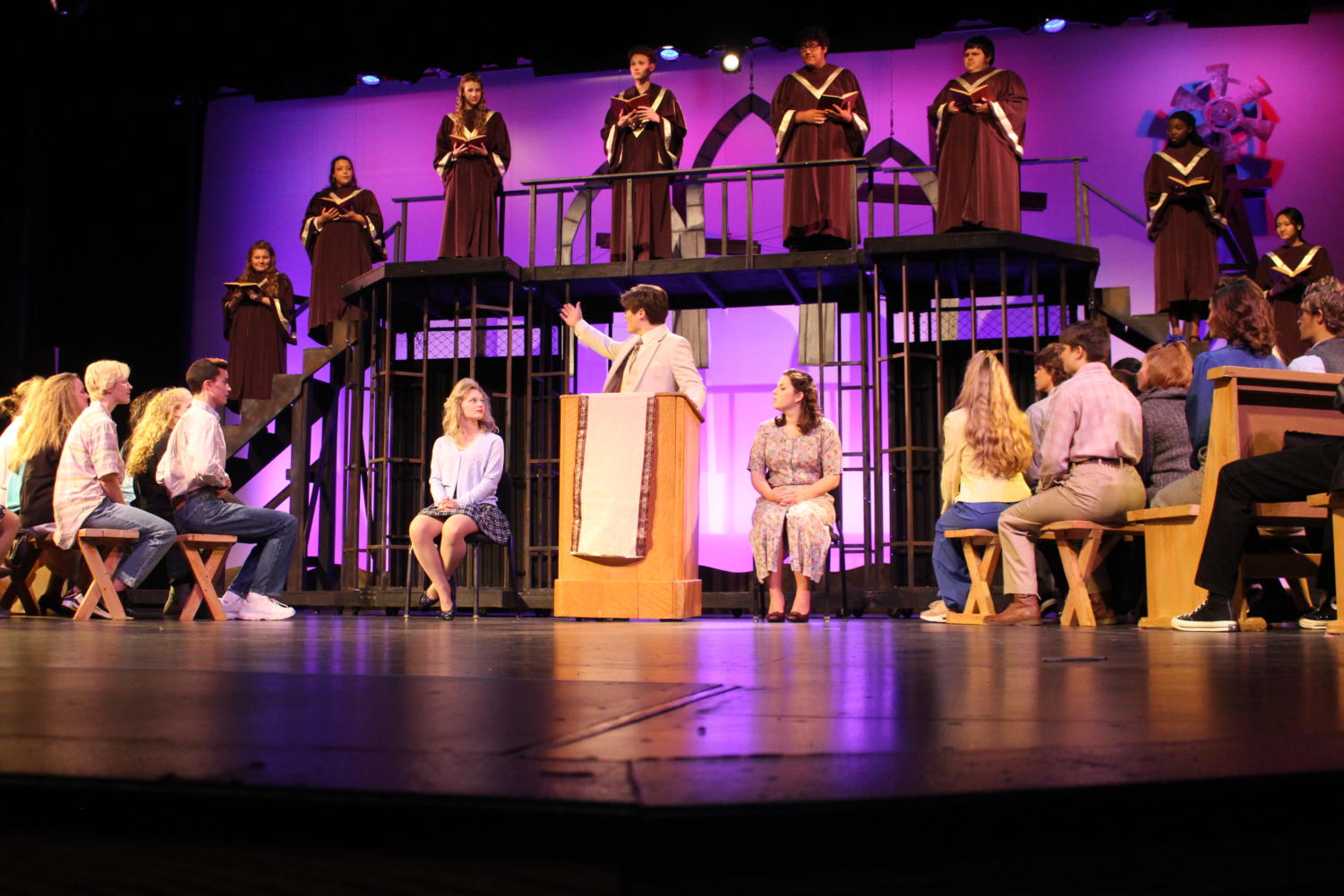 The cast of Footloose listens to Reverend Moore, played by junior Charlie Gross, preach in the opening scene. 