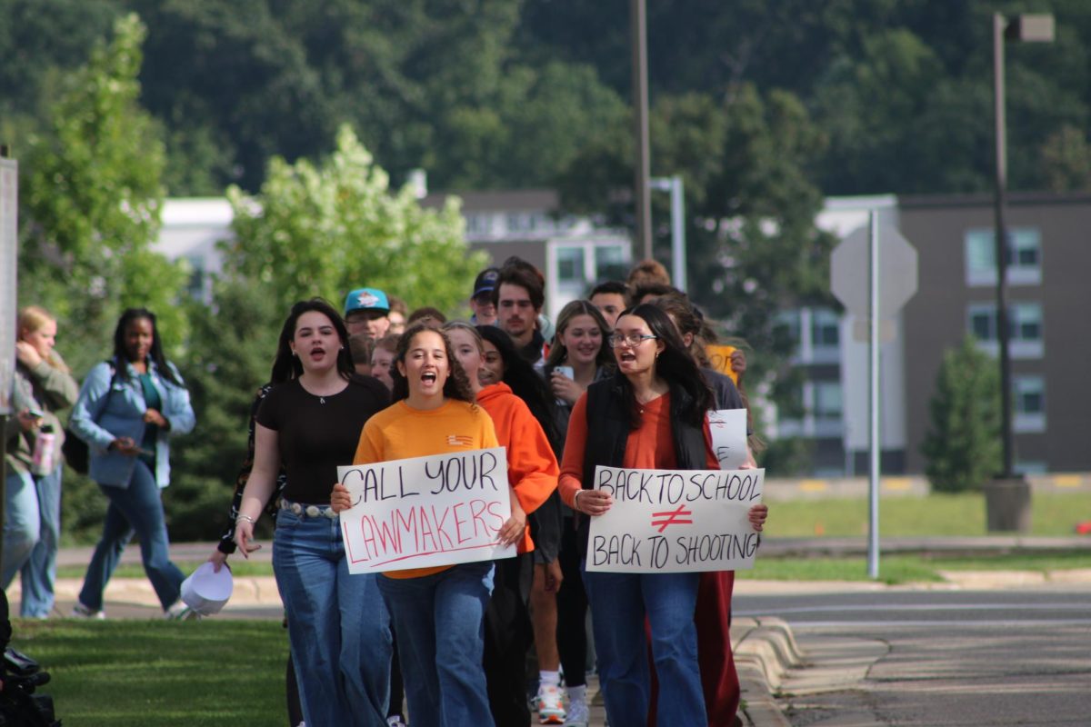 With peers surrounding them, junior Riya Bhatt and sophomore Madeleine Duhn led the walkout on Friday, carrying protest signs instead of backpacks. One sign reads “Call your lawmakers” while the other states “Back to school ≠ back to shooting,” echoing students' demand for legislative action against gun violence. Reflecting on the event, Duhn says, "I hope they are moved and realize that there is no age limit on forcing change, anyone of all ages can do it,”. Photograph by Layla Carpenter